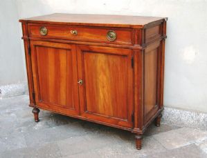 Elegante credenza a due ante e due cassetti in noce lastronato.Piano in massello. Piedi finali torniti ed intagliati .belle forme architettoniche fine XVIII° sec.
